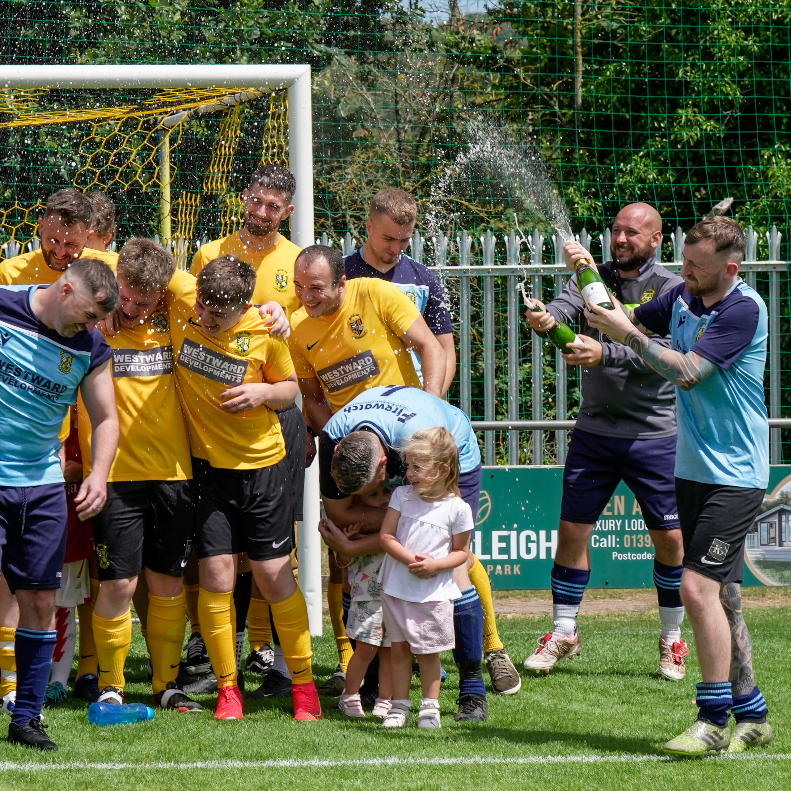 Group of football players celebrating with champagne
