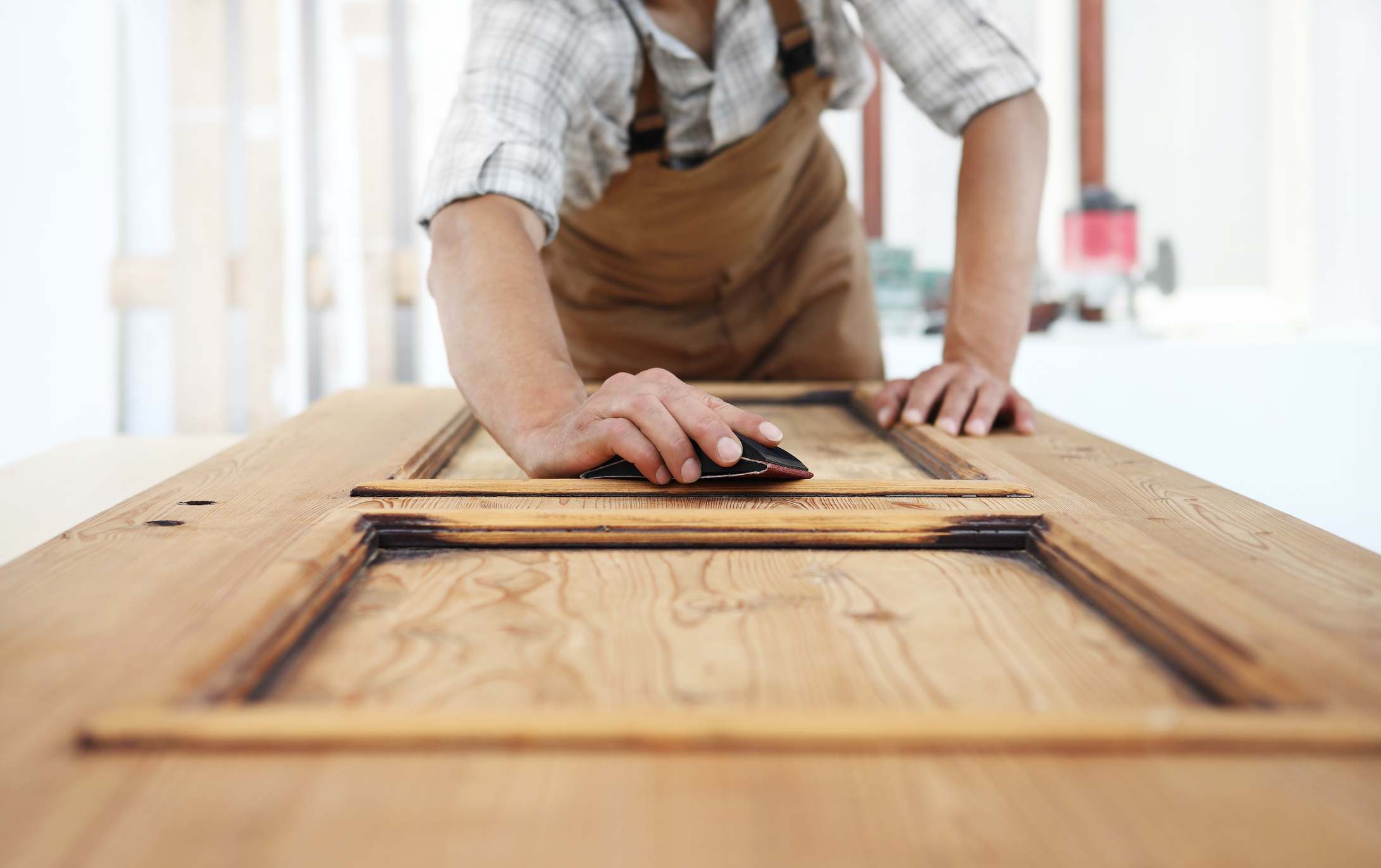 Person Sanding A Wooden Door